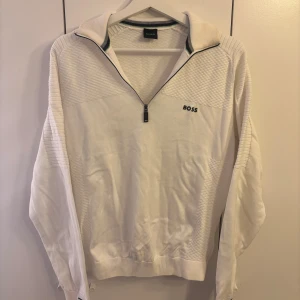 Vit half zip tröja från BOSS - Snygg vit långärmad tröja från BOSS med half zip och diskret logga på bröstet. ordinarie pris 2700