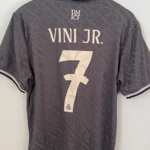  Real Madrid player edition  - Säljer en riktig fin Real Madrid 24/25 player edition 24/25 med tryck bakom VINI JR #7. En riktig skön tröja att ha på sig när man tränar eller bara vanligt under vardagen. Har använts några gånger.   Undrar du över något eller vill ha fler bilder så är det bara att fråga på. Tveka inte!