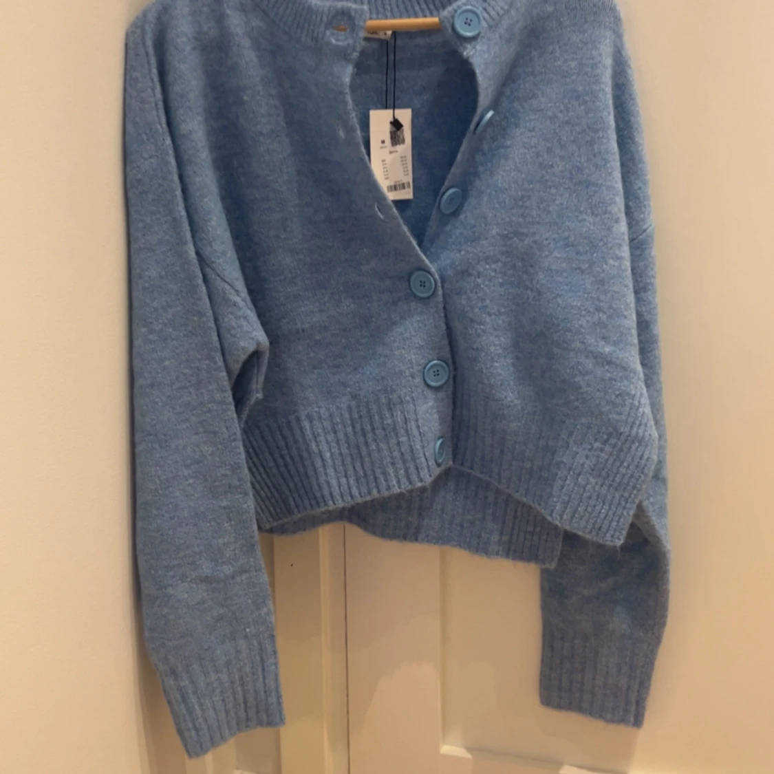 Ljusblå stickad kofta med stora knappar