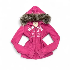 Hollister Fur Hoodie - ✨ Säljer en unik fur hoodie från märket (Hollister) ✨ Pälsen är ditsatt i efterhand för en personlig och trendig look. Storleken är (S), men den kan även passa (Xs) beroende på önskad passform. Eftersom plagget är second hand kan mindre defekter jag missat förekomma! – se gärna min bio för mer info.  💎 Priset är fast och ej förhandlingsbart.  Tvättråd: Handtvätta i ljummet vatten, var försiktig med pälsen, alternativt tvätta tröjan i en tvättpåse i tvättmaskinen 30-40grader. Undvik torktumlare. 