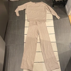 Beige stickade byxor och tröja från BikBok - Mysigt beige stickat set från BikBok i mjukt material. Har bara använt 2 gånger det är som nytt jag säljer då dom inte kommer till användning:)