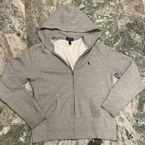 Grå zip hoodie från Ralph Lauren  - En stilren zip hoodie från ralph lauren, en varm men snygg tröja perfekt för detta höstväder. Intresserad? Lämna gärna bud. Skriv privat om funderingar mm
