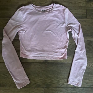 Ljusrosa croppad långärmad topp  - Säljer en ljusrosa croppad långärmad topp från Shein. Enkel och stilren design med rund halsringning och mjukt material som känns skönt mot huden. Perfekt att matcha med jeans eller kjol för en chill look.