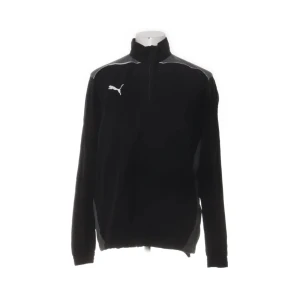 Svart vindjacka från Puma i storlek L - Svart vindjacka från Puma med vita detaljer och logga på bröstet. Jackan har hög krage, halv dragkedja och är tillverkad i 100% polyester. Perfekt för dig som gillar sportig stil och vill ha en lätt jacka med snygg passform.