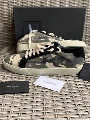 Archive Saint Laurent camo skor🔥 - Nypris ~7000 kr. Väldigt sällsynt model. Materialet är canvas med mockadetaljer och insida i skinn. 🔥Såklart äkta med orderbekräftelse, äktehetscertifikat samt allt annat ORG som låda och dust bag. 28 CM📏 är innermåttet. Priset är inte hugget i sten 🪨 svarar på alla frågor stora som små❤️Skit bra skick. Öppen för byten🗣️