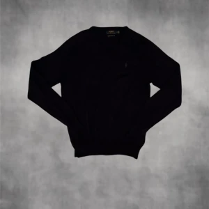 Mörkblå polo Ralphlauren tröja - Säljer en v ringad mörkblå tröja i storlek M. Ser svart ut på bilderna men är mörkblå egentligen. Inga direkta defekter bara ett igensytt hål som syns endas vid nära ispenktion. En schysst casual tröja funkar till de flesta tillfällen. Kontakta vid minsta fundering// Nordic Closet