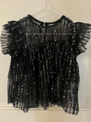 Blus med palietter - Svart blus med glittriga palietter från gina tricot. Storlek 134-140. Passar perfekt till nyår.