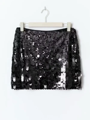 Svart paljettkjol i minilängd - Säljer en svart minikjol täckt av glittriga paljetter som ger en riktigt snygg och festlig look. Kjolen har rak passform och är perfekt för dig som vill sticka ut. Materialet är syntet och paljetterna reflekterar ljuset snyggt.