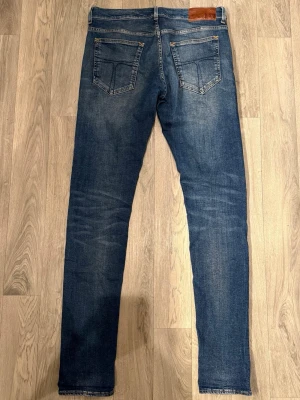 Tiger of Sweden Slim Jeans Blå W30 L34 - Blåa Tiger of Sweden Slim Jeans i fint skick med sjuk tvätt i storlek W30/L34. Mått - Midja: 40cm, Benlängd: 107,5cm. Modellen är 185cm & 63kg. Hör av dig vid funderingar!🤩