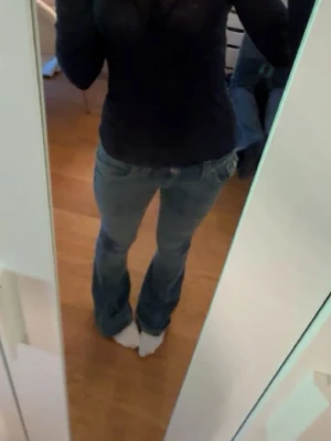 True Religion bootcut jeans blå - Säljer ett par blå jeans från True Religion med bootcut-snitt och snygga kontrastsömmar. Låg midja. Baksidan har stora fickor med lock och dekorativa vita broderier samt metallknappar. Klassisk jeanslook med coola detaljer och tydlig logga på etiketten. Lite slitage där nere märks knappt! 