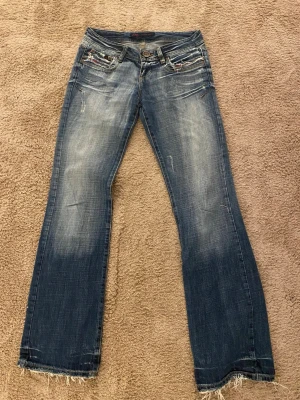 Blå bootcut jeans från LTB - Super snygga low waist jeans från LTB. De har frans-detaljer på fickorna och längst ner på benen. Jag köpte dem begagnade men är i bra skick utan defekter💕Hör av dig om du är intresserad, priset går att diskutera💕