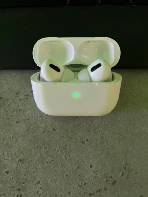 AirPods Pro (minst 300kr) - Säljer ett par AirPods Pro med laddningsetui. Hörlurarna är i fint skick med endast mindre tecken på normalt bruk. Aktiv brusreducering och trådlös laddning. Perfekt för musik, samtal och träning. Levereras med originaletui.