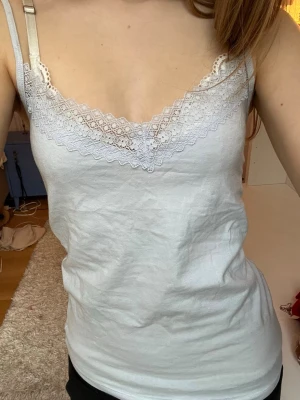 Ljusblått linne med spetsdetaljer - Säljer ett ljublåttlinne med spets! Den har justerbara axelband♥️