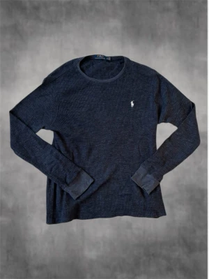 Mörkblå långärmad tröja Polo Ralph Lauren - Säljer en mörkblå långärmad tröja från Polo Ralph Lauren i ribbad bomull. Tröjan är i storlek XL och är True to size.Tröjan har rund hals och den klassiska broderade loggan på bröstet. Perfekt för dig som gillar stilrena och bekväma plagg med premiumkänsla.