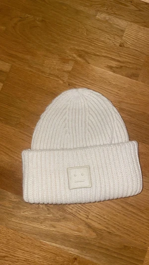Acne mössa - Säljer denna mössa i färgen vit då den ej kommer till användning, mycket bra skick knappt använd endast fåtal gånger
