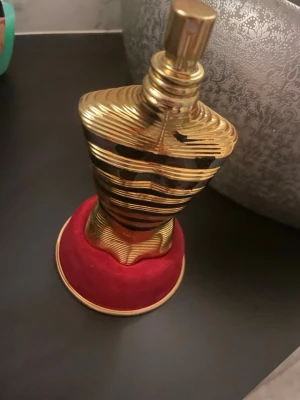 Lyxig Jean Paul Gaultier parfym - Unik och iögonfallande parfymflaska i guld med röd bas. Volymen är 125 ml (4.2 fl. oz). Perfekt för dig som vill sticka ut med din stil. Snygg originalförpackning medföljer.