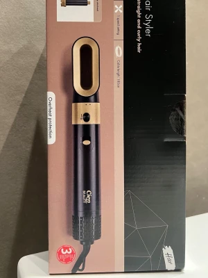Cien Beauty Multi Hair Styler - Multi Hair Styler från Cien Beauty med svart och guld design. Inkluderar två locktillbehör, en halvrund borste, en rund borste, hårfön-tillbehör och en förvaringsväska. Kabeln är 180 cm lång och stylern har två värmeinställningar samt överhettningsskydd.