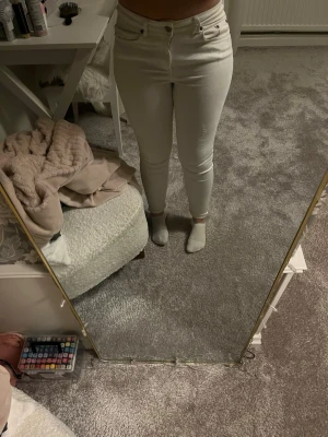Vita skinny jeans med hög midja - Säljer ett par vita skinny jeans med hög midja och klassisk design. Byxorna har smal passform och är hyffsat stretchiga. Bakfickorna är som vanliga fickor!