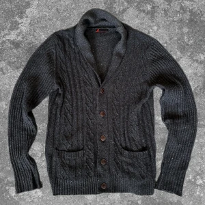 Mörkgrå stickad cardigan  - Trendig och stilren bra nu i höst/vinter. Måtten: A=49cm B=38cm C=40cm D=64cm. Bra skick-defekt nopprig! Hör av dig vid frågor. Pris kan diskuteras!