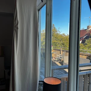 Ljus långklänning med rynk i sidan - Säljer en stilren och enkel långklänning i ljus beige färg. Klänningen är ärmlös med rund halsringning och har en snygg rynkdetalj i sidan som ger en cool touch. Materialet känns mjukt och stretchigt, perfekt för en elegant stil 