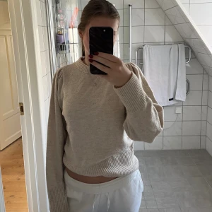 Beige stickad tröja med puffärm - Säljer en beige stickad tröja med puffade axlar och breda ribbade muddar vid ärmslut och nederkant. Superfin men kommer inte till användning🤎