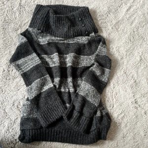 Randig polotröja i grått - En jätte söt polotröja från Wallis i mörkgrå och ljusgrå ränder. Tröjan har bred polokrage med tre dekorativa knappar och ribbade muddar. Tröjan är köpt second hand och i jätte fint skick!