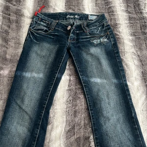 Blå jeans från Crazy Age med broderi - Snygga blå jeans från Crazy Age med coolt ljusblått broderi på fickorna och slitna detaljer. Midjemått 36 innerbenslängd 80. Följ för mer <3