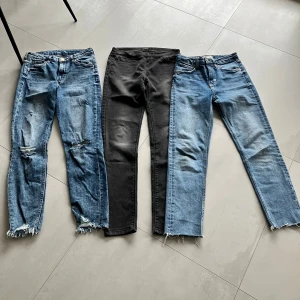 3-pack jeans i olika färger och stilar - Ett par blåa jeans med trasiga detaljer och råa benslut H&M 34, ett par svarta skinny jeans Stradivarius 36 (men liknar 34or) och ett par ljusblå jeans med råa benslut Zara 34. Alla har klassisk femficksdesign och dragkedja. Perfekta för dig som gillar olika stilar och vill variera din look.