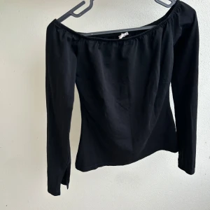 Svart offshoulder långärmad topp - Snygg svart offshoulder topp med långa ärmar och smal passform och slits i slutet av armarna som på bilden. Ganska stretchig men inte jätte mycket den passar XS-S