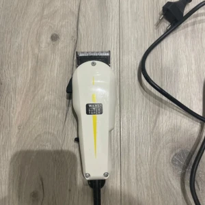 Wahl Super Taper - Professionell hårtrimmer Wahl Super Taper med sladd, inklusive kammar, hårklämmor och kam. Trimmern är i gott skick med endast mindre yttre slitage. Perfekt för både hemmabruk och salong. Kraftfull motor och justerbara längder för flexibel styling.