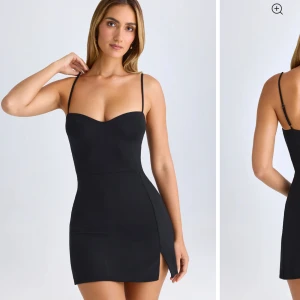 Svart tight miniklänning med slits - Supersnygg svart miniklänning med tunna axelband och figurnära passform. Klänningen har en liten slits på sidan och en söt, hjärtformad urringning. Den är perfekt till att klä upp och klä ner. Jag har aldrig använt den då jag råkade köpa fel storlek. Älskar den ananrs. 