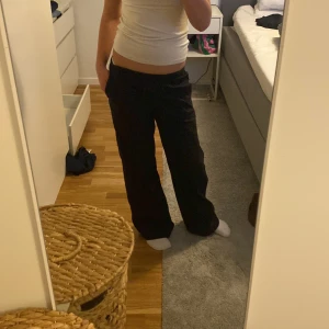 Svarta linne byxor från H&M - Svarta byxor från H&M med bred passform och resår i midjan. Byxorna har raka ben och en enkel bakficka. Tillverkade i mjuk bomull, perfekta för en chill och avslappnad stil. Har aldrig använda dessa förut bara provat en gång men har tagit av prislappen 