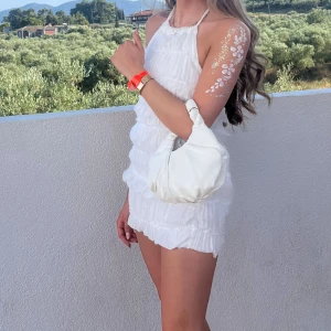 Vit rubbad klänning - Fin rubbad kläddning som är öppen i ryggen, inga fläckar och är i fint skick. Knyte i halsen. 