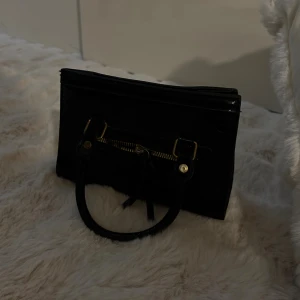 Väska - Liten handväska. Axelband finns med. 