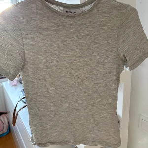 Grå basic t-shirt från Weekday - En enkel och stilren grå t-shirt från Weekday. Modellen är klassisk med rund halsringning och korta ärmar. Tillverkad i mjuk bomull som är skön mot huden. Den är bara skrynklig för den legat i en påse en stund😅