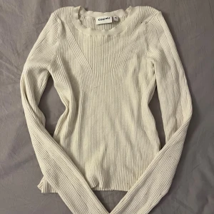 Långärmad ribbad tröja  - Säljer denna långärmade ribbade gräddvita tröjan från Kappahl. Den är väldigt skön i tyget. Använda enstaka gånger. Det har blivit en maska på magen men den syns inte jätte mycket.