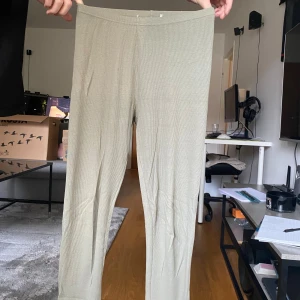 Gröna ribbade leggings - Säljer ett par gröna ribbade leggings med hög midja. De är stretchiga och sitter tight, perfekta för en chill och avslappnad stil. Materialet känns mjukt mot huden och passar bra till oversized tröjor eller hoodies.