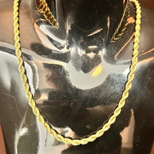 Guldigt tvinnat halsband - Snyggt halsband i guldig färg med tvinnad kedja som ger en cool och trendig look. Perfekt accessoar för att lyfta din outfit med lite extra bling. Passar dig som gillar stilrena men ändå iögonfallande smycken. Inte äkta men färgen gick inte bort ändå.