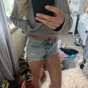 Ljusblå jeansshorts med slitningar  - Snygga ljusblå jeansshorts från new yorker i storlek XXS. De har flera slitningar framtill för en trendig, avslappnad look. Klassisk femficksmodell med knapp och dragkedja. Perfekta för varma dagar.