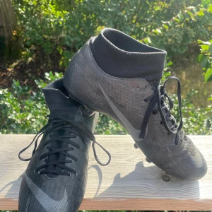 Nike Mercurial Superfly Academy FG/MG storlek 40,5 - Nike Mercurial Superfly Academy FG/MG (för naturgräs och konstgräs) i storlek 40,5. Svarta med gråa detaljer. 