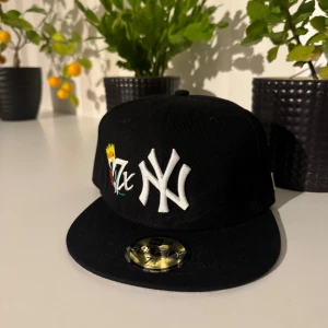 Svart New Er Yankees keps 59FIFTY - Snygg svart New Er 59FIFTY keps med New York Yankees broderad logga i vitt framtill och färgglada detaljer. Baksidan har broderade World Series Champions årtal och MLB-logga. Klassisk rak skärm och Cooperstown Collection-märke på insidan.