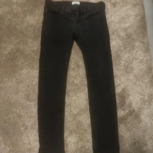Svarta jeans från Stone Island - Svarta jeans från Stone Island med klassisk broderad logotyp på bakfickan. Modellen har rak passform och normal midja. 