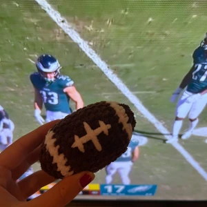 Virkad amerikansk fotboll - En virkad amerikansk fotboll.                                        Funkar super som bla. leksak, djurleksak, gosedjur, dekoration och även som nyckelring om man önskar det. Jag har har gjort den själv och kan även göra fotbollar, rugbybollar eller något annat om det önskas! Man kan även få den större eller mindre! Den är gjort med ett väldigt mjukt garn!