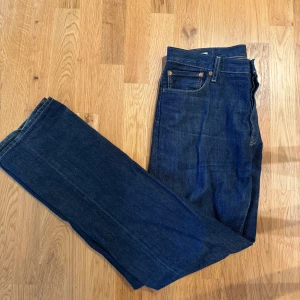 Levi's 501 mörkblå jeans W34 L34 - Klassiska Levi's 501 jeans i mörkblå denim. Rak passform med fem fickor och knappgylf. Snygga kontrastsömmar och ikonisk läderpatch bak i midjan. Perfekta för dig som gillar tidlös stil och vill ha ett par jeans som funkar till allt. Görgoa byxor, skicka om de är något bara🫡
