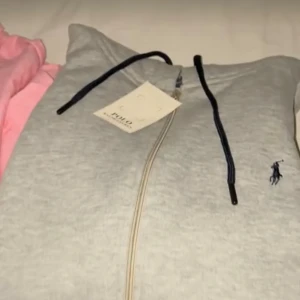 Grå Ralph lauren full zip hoodie (läs beskrivningen) - Säljer min gråa raffe full zip hoodie, har inte några bra bilder med tröjan just nu, men är det materialet som visas i de 2 första bilderna och samma typ tröja som den vita som visas i de 3 sista bilderna, lägger upp bättre bilder imorgon, men fri frakt idag den 9de mellan 20:00 till 21:00 GÅR EJ NER NÅGOT ALLT FRÅN 600!