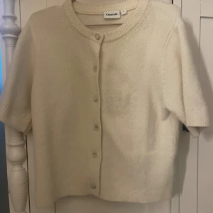 kortärmad stickad tröja med knappar - kortärmad stickad tröja med knappar ifrån kappahl! väldigt ljus creme färgad!