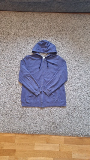 Lila hoodie från Champion med dragkedja - Snygg skön lila Champion hoodie med dragkedja i storlek XL, men skulle nog säga den passar mer som L/M. Använd fåtal gånger och skicket är riktigt bra. Den har två fickor, luva och dragkedja. Skick: 8/10