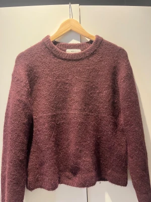 Vinröd fluffig stickad tröja Gina Tricot - Mysig vinröd stickad tröja från Gina Tricot i storlek XS. Tröjan har en rund halsringning och är tillverkad i en ullblandning som ger en fluffig och mjuk känsla. Långärmad och med en loose passform, perfekt för kyliga dagar. använd fåtal gånger. Kom med pris förslag