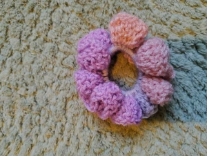 Rosa och lila virkad scrunchie - Superfin handgjord virkad scrunchie i mjuka nyanser av rosa och lila. Den har en fluffig och bubblig design som ger håret en extra söt touch. Perfekt för att piffa upp din frisyr med lite färg och charm. Virkad av mig!
