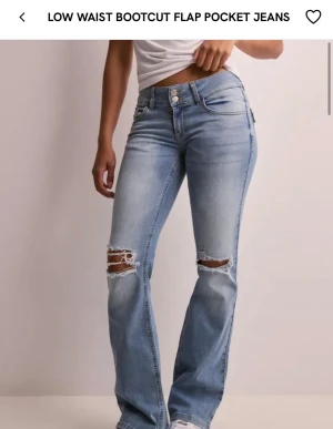 Low waist jeans med hål - Säljer blåa jeans med hål på knäna från Nelly, hålen har blivit lite sämre men annars är de i bra skick!💓